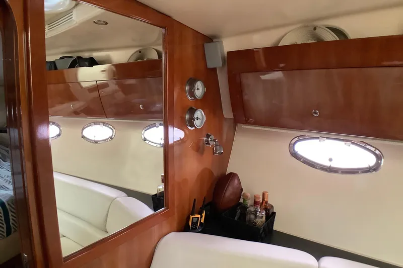 Perseides Yacht Photos Pics Luxurious interior of 2005 Regal Commodore 3860 yacht with wood paneling and porthole windows.