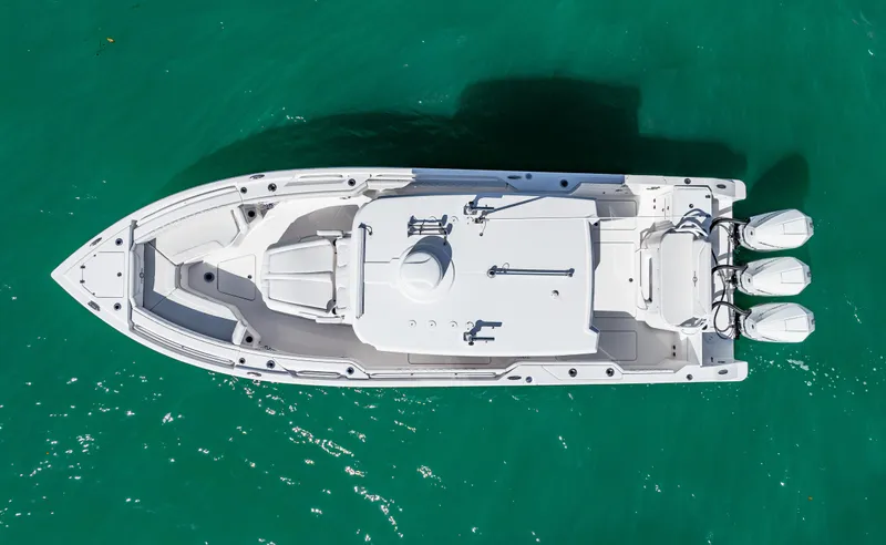 Tt Aloan At Last Yacht Photos Pics Aerial view of 2023 Fountain 32 NX boat on turquoise water.