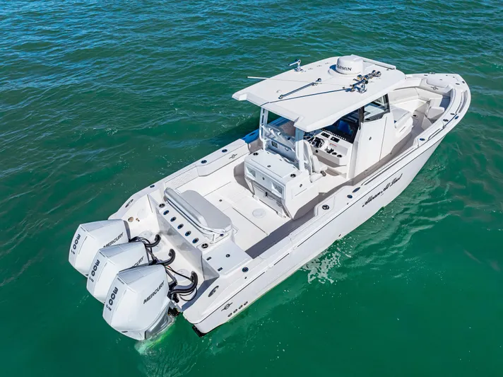 Tt Aloan At Last Yacht Photos Pics 2023 Fountain 32 NX boat with triple engines on clear water.