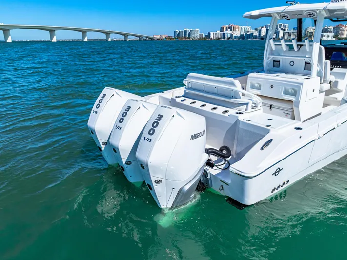 Tt Aloan At Last Yacht Photos Pics 2023 Fountain 32 NX boat with triple Mercury engines on clear blue water.