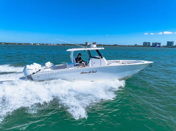 Tt Aloan At Last Yacht Photos Pics 2023 Fountain 32 NX boat cruising on open water under clear blue sky.