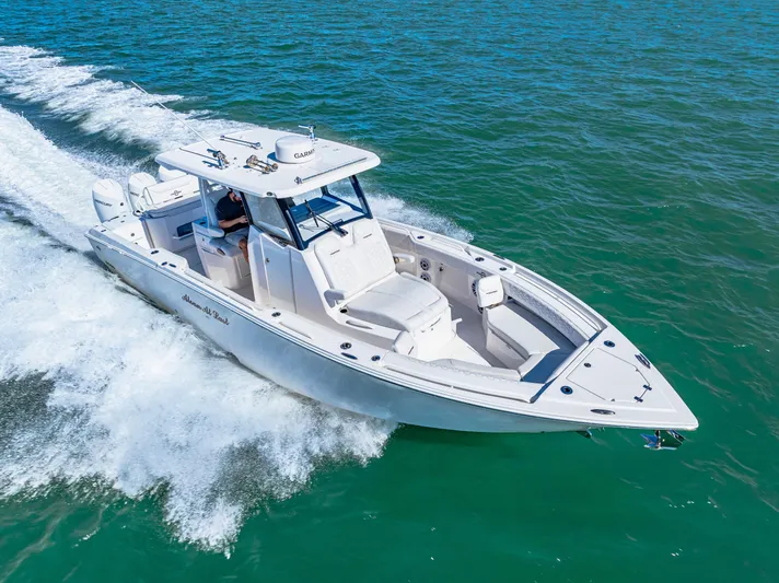 Tt Aloan At Last Yacht Photos Pics 2023 Fountain 32 NX boat cruising on clear blue water.