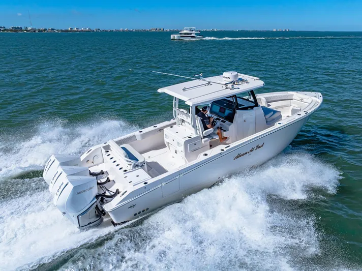 Tt Aloan At Last Yacht Photos Pics 2023 Fountain 32 NX boat cruising on open water, showcasing powerful engines and sleek design.