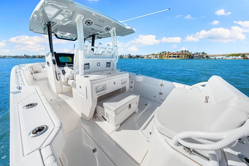 Tt Aloan At Last Yacht Photos Pics 2023 Fountain 32 NX boat interior on blue water, featuring modern seating and controls.