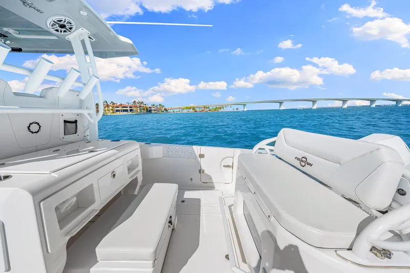 Tt Aloan At Last Yacht Photos Pics 2023 Fountain 32 NX boat interior with ocean view and bridge in background.