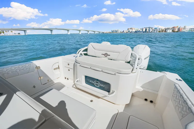 Tt Aloan At Last Yacht Photos Pics 2023 Fountain 32 NX boat on water with cityscape and bridge in background.