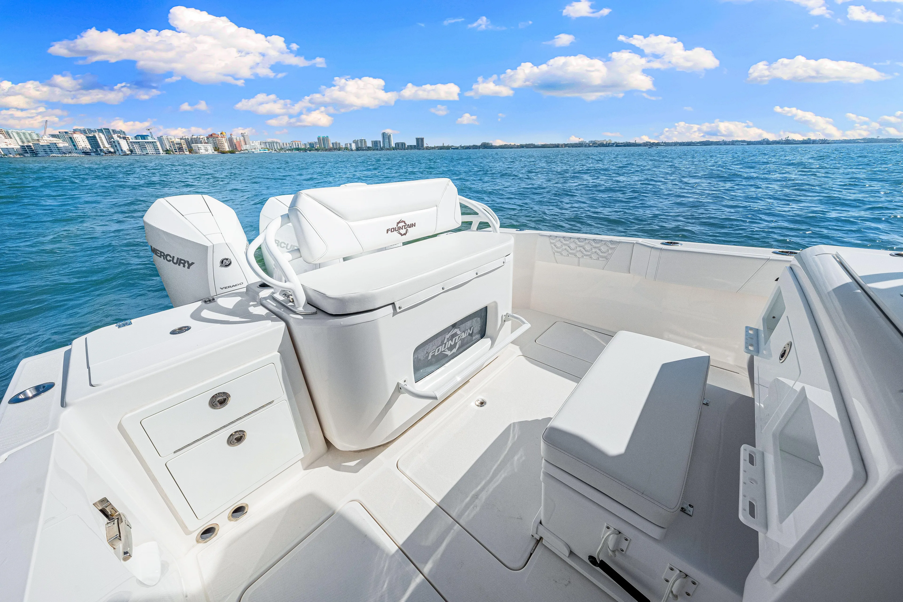 Tt Aloan At Last Yacht Photos Pics 2023 Fountain 32 NX boat interior with ocean view, featuring seating and storage.