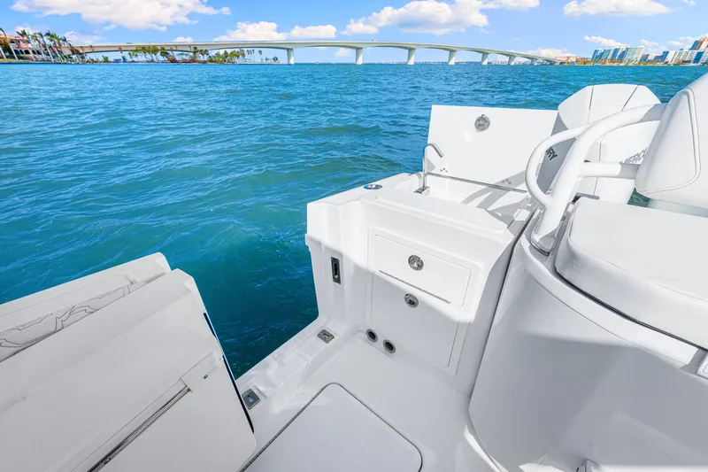 Tt Aloan At Last Yacht Photos Pics 2023 Fountain 32 NX boat interior with ocean view and bridge in background.