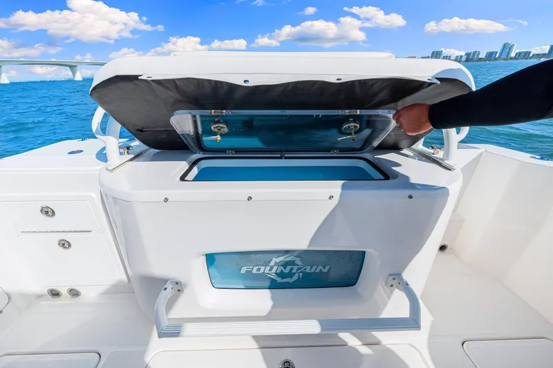 Tt Aloan At Last Yacht Photos Pics 2023 Fountain 32 NX boat with open storage compartment on deck, ocean view background.