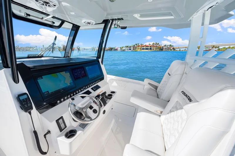 Tt Aloan At Last Yacht Photos Pics 2023 Fountain 32 NX boat interior with modern dashboard and luxurious seating.