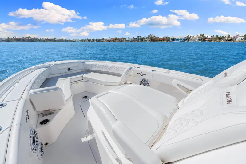 Tt Aloan At Last Yacht Photos Pics 2023 Fountain 32 NX boat with luxurious seating on a sunny day.
