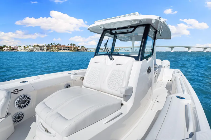 Tt Aloan At Last Yacht Photos Pics 2023 Fountain 32 NX boat on blue water with bridge and buildings in background.
