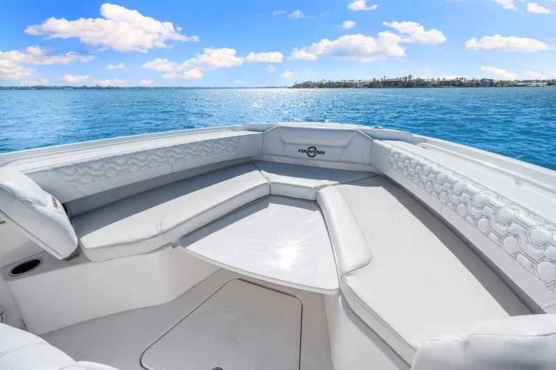 Tt Aloan At Last Yacht Photos Pics 2023 Fountain 32 NX boat interior with luxurious seating on a sunny day.