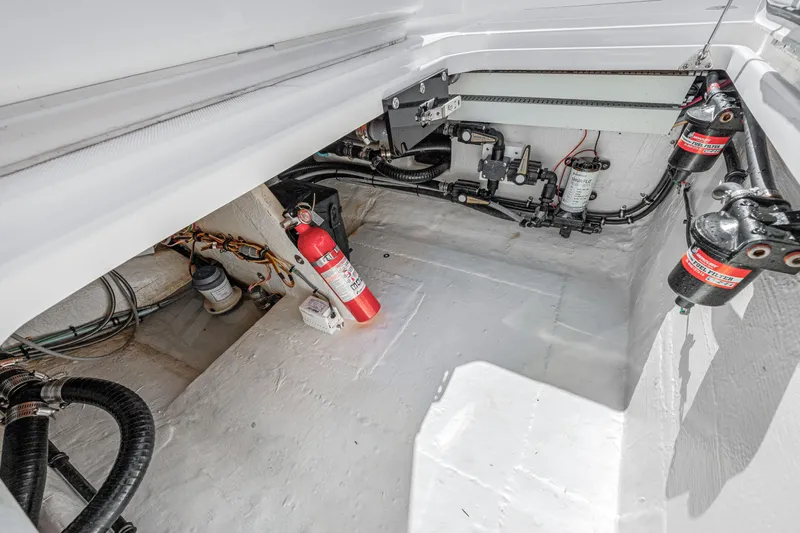 Tt Aloan At Last Yacht Photos Pics 2023 Fountain 32 NX boat engine compartment with fire extinguisher and mechanical components.