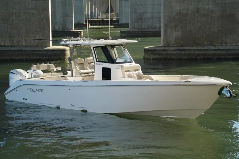  Yacht Photos Pics 2024 Solace 32 CS boat cruising under a bridge in calm waters.