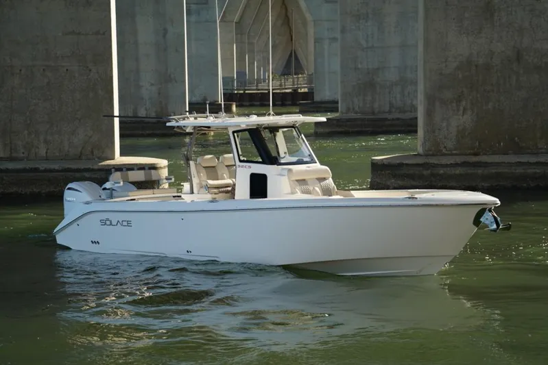  Yacht Photos Pics 2024 Solace 32 CS boat cruising under a bridge in calm waters.
