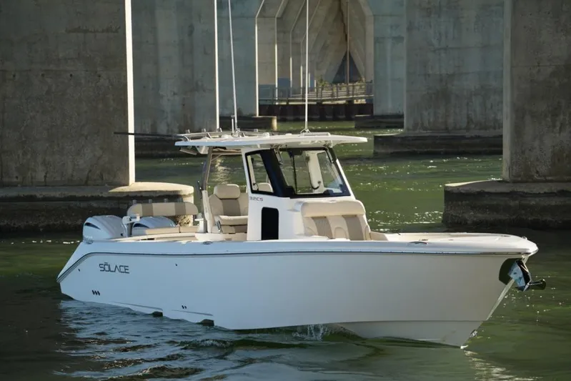  Yacht Photos Pics 2024 Solace 32 CS boat cruising under a bridge in calm waters.