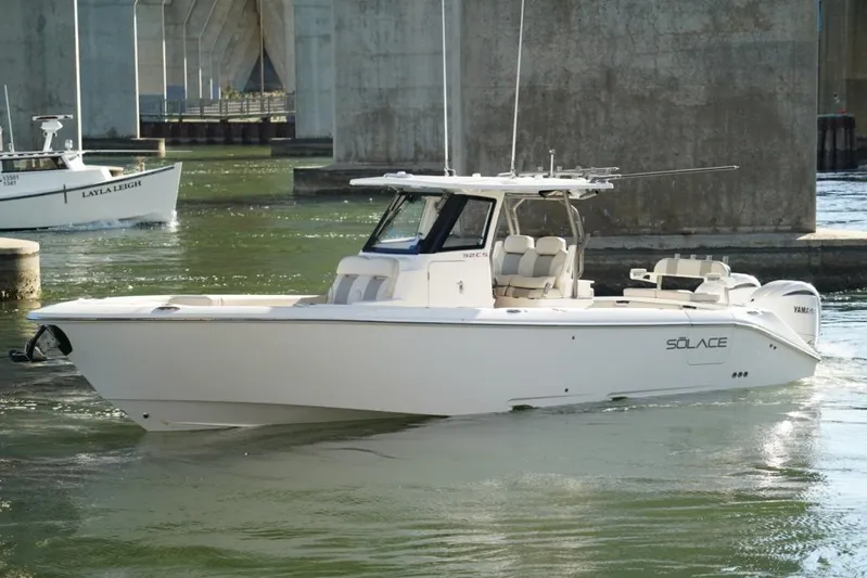  Yacht Photos Pics 2024 Solace 32 CS boat navigating under a bridge in calm waters.