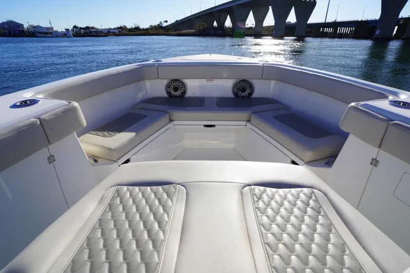  Yacht Photos Pics Luxurious seating on 2024 Solace 32 CS boat, with scenic water and bridge view.