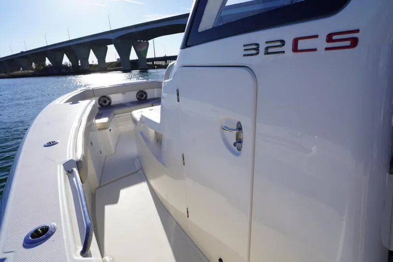  Yacht Photos Pics 2024 Solace 32 CS boat, sleek design, docked near a bridge on sunny day.