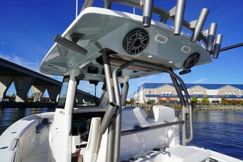  Yacht Photos Pics 2024 Solace 32 CS boat with advanced features, docked near a bridge and waterfront buildings.