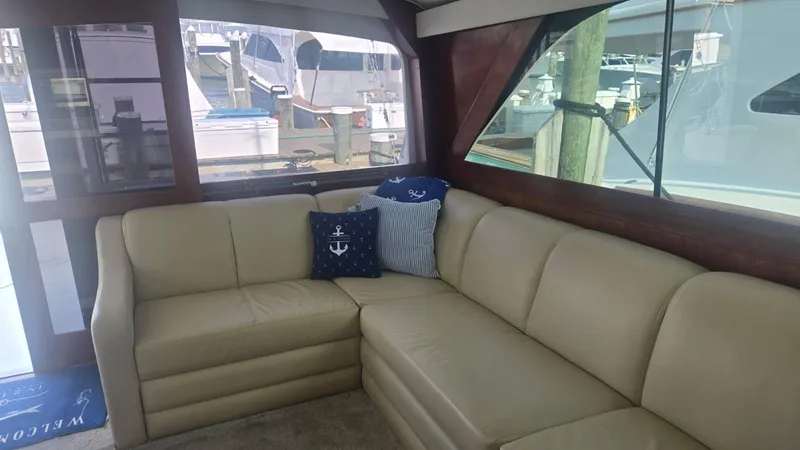 In 2 Deep Yacht Photos Pics Interior of 1984 Ocean Yachts 46 Super Sport with beige leather seating and nautical-themed pillows.