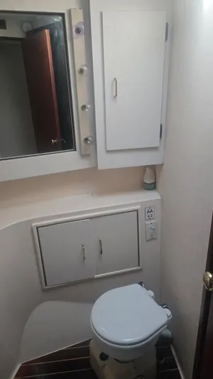 In 2 Deep Yacht Photos Pics Bathroom interior of 1984 Ocean Yachts 46 Super Sport, featuring toilet and storage cabinets.