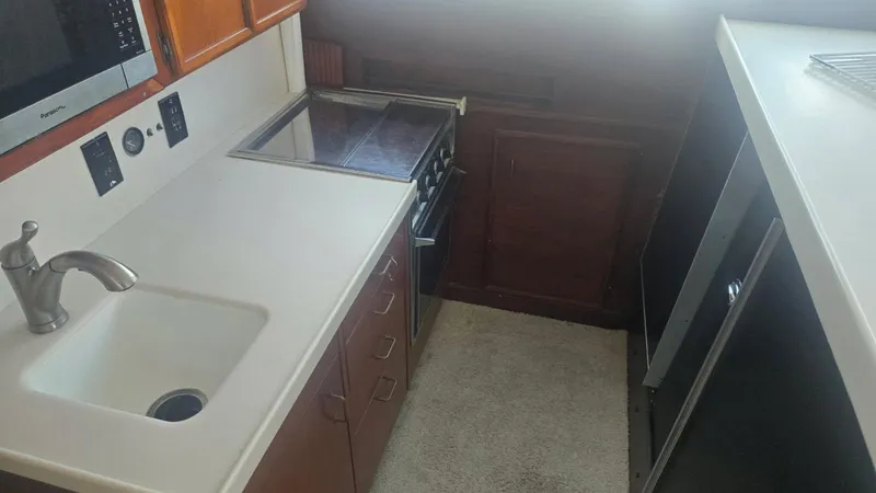 In 2 Deep Yacht Photos Pics 1984 Ocean Yachts 46 Super Sport kitchen with sink, stove, and microwave.