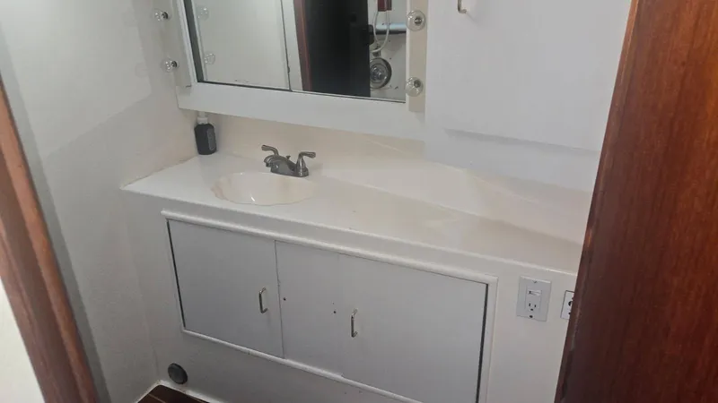 In 2 Deep Yacht Photos Pics 1984 Ocean Yachts 46 Super Sport bathroom with sink, mirror, and storage cabinets.