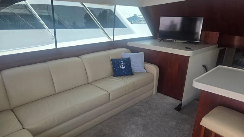 In 2 Deep Yacht Photos Pics Luxurious interior of 1984 Ocean Yachts 46 Super Sport with beige sofa and TV.