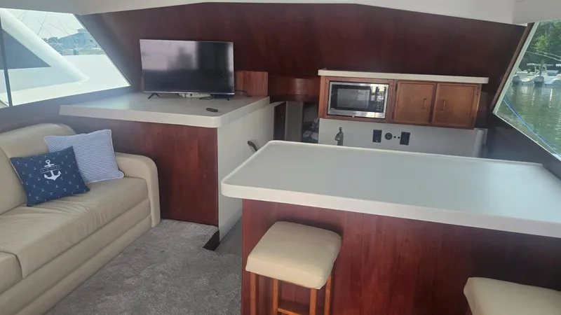 In 2 Deep Yacht Photos Pics Interior of 1984 Ocean Yachts 46 Super Sport with sofa, TV, and kitchenette.