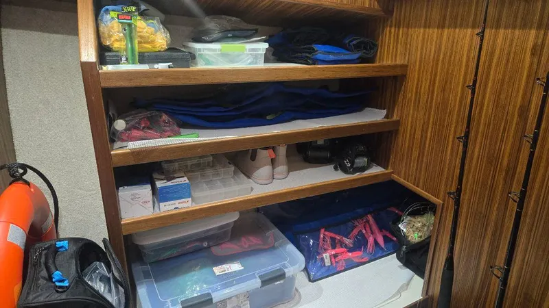In 2 Deep Yacht Photos Pics Storage shelves on a 1984 Ocean Yachts 46 Super Sport, filled with boating supplies.