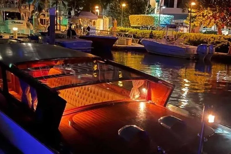 Venice In Miami Yacht Photos Pics Luxurious 2002 A&M Manufacturing Veneziano Convertible boat docked at night, illuminated interior.