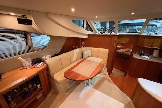 Go Jump In The Lake Yacht Photos Pics Interior of 2003 Silverton 39 Motor Yacht with cozy seating and dining area.