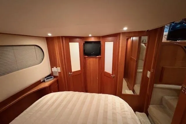Go Jump In The Lake Yacht Photos Pics Interior of 2003 Silverton 39 Motor Yacht bedroom with wood paneling and TV.