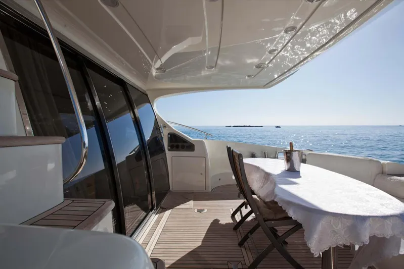  Yacht Photos Pics Luxurious 2006 Azimut 62 yacht deck with ocean view, featuring elegant dining setup.