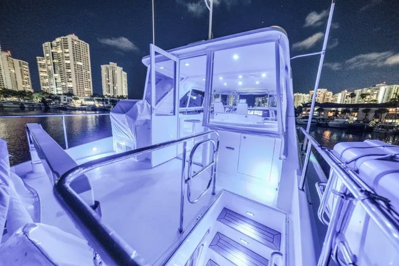 Amajen Yacht Photos Pics Luxurious 2006 Cheoy Lee Motor Yacht illuminated at night, city skyline in background.