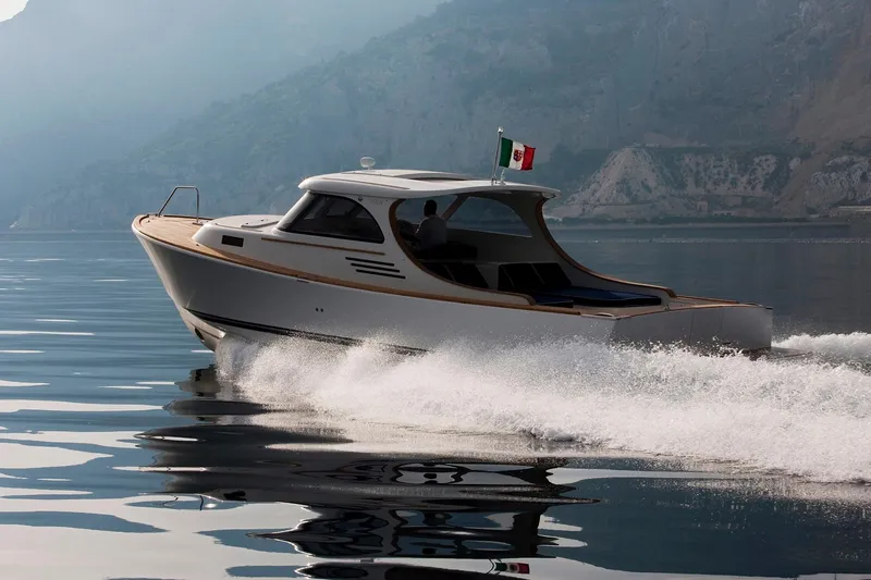 36 Yacht Photos Pics Sleek Toy 36 motorboat cruising on calm waters, 2025 model, with a flag waving.