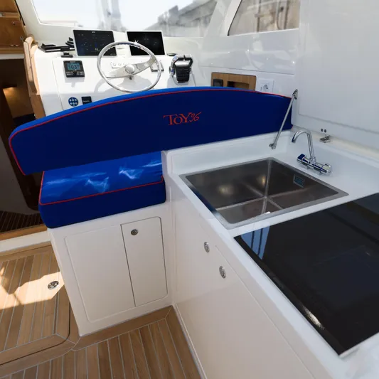 36 Yacht Photos Pics Modern Toy 36 yacht interior with steering, sink, and blue seating, 2025 model.