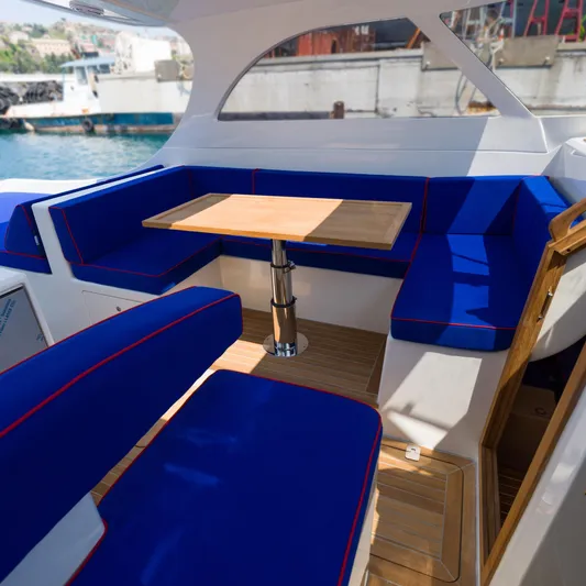 36 Yacht Photos Pics Luxurious Toy 36 yacht interior with blue seating and wooden table, 2025 model.