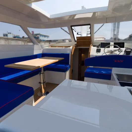 36 Yacht Photos Pics Modern Toy 36 yacht interior with blue seating and wooden table, 2025 model.