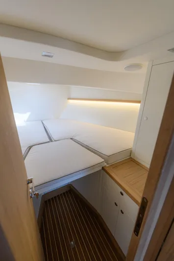 36 Yacht Photos Pics Compact cabin interior with a neatly arranged bed and wooden flooring, Toy 36 model, 2025.