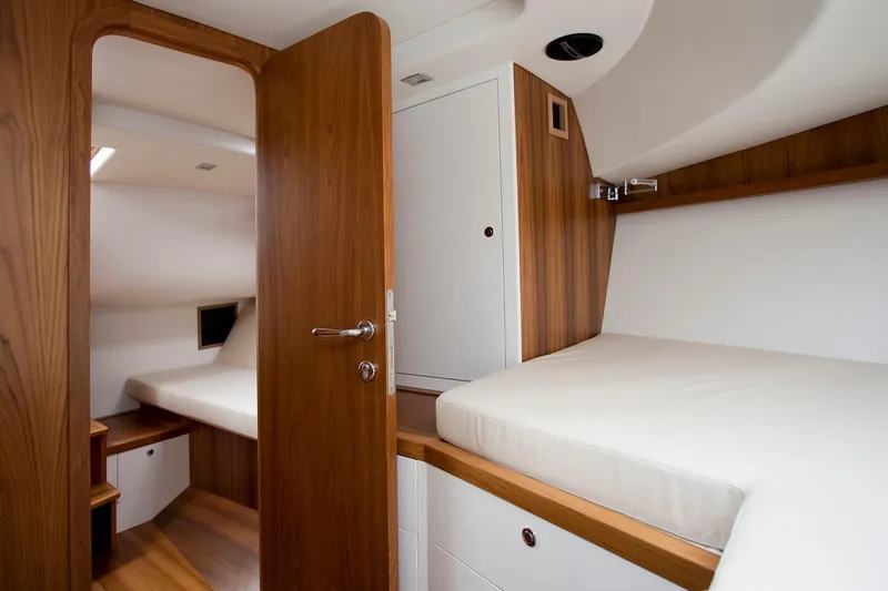 36 Yacht Photos Pics Cozy cabin interior of Toy 36 model, featuring wooden finishes and comfortable bedding, 2025 design.