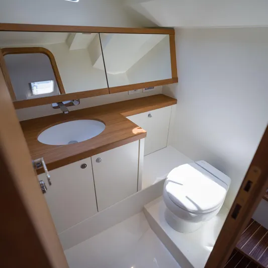 36 Yacht Photos Pics Modern yacht bathroom with wooden accents, featuring a sink, mirror, and toilet. Toy 36, 2025 model.