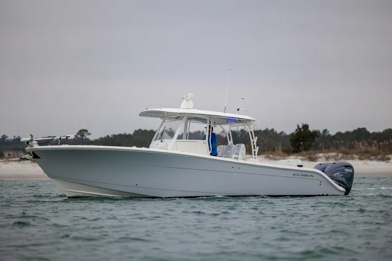  Yacht Photos Pics 2020 Cobia 350 Center Console boat on water near sandy shoreline.