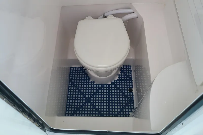  Yacht Photos Pics 2023 Contender 25 Tournament boat toilet with blue mat flooring.