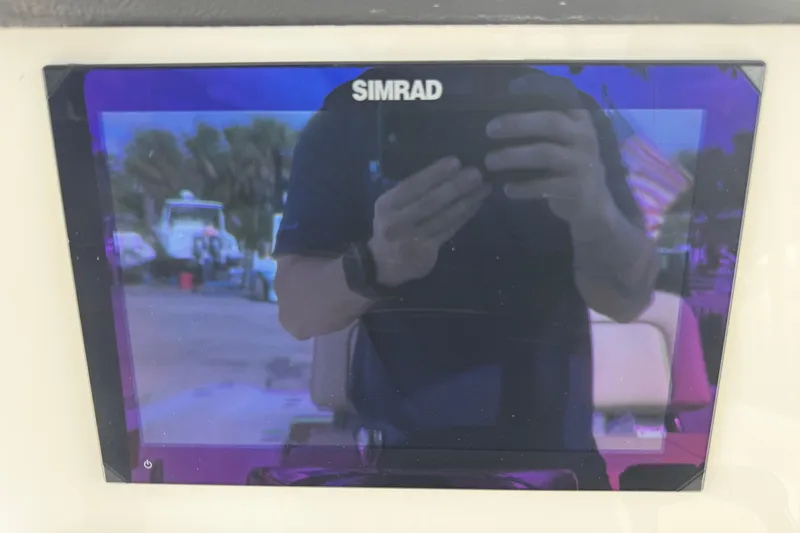  Yacht Photos Pics Simrad display on 2026 Sea Pro 262 Offshore boat, reflecting surroundings.