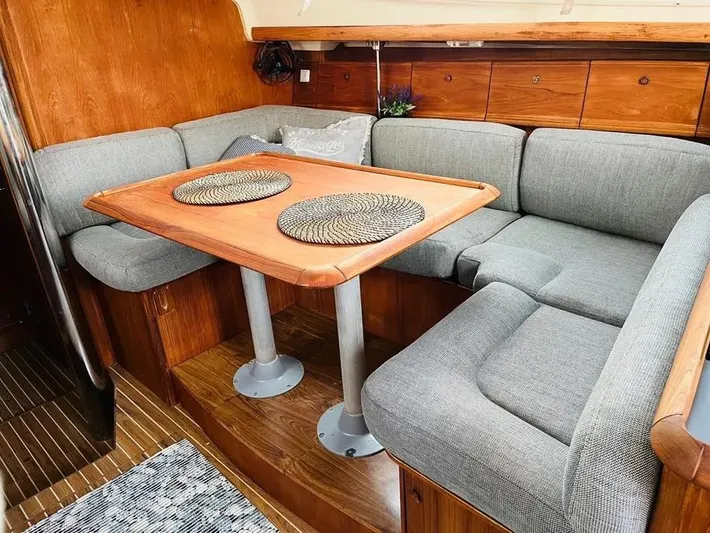  Yacht Photos Pics Interior of 2001 Jeanneau Sun Odyssey 43 DS with cozy seating and wooden table.