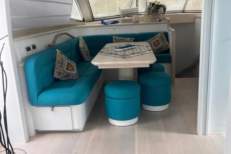  Yacht Photos Pics Luxurious 2005 Posillipo Technema 80 yacht interior with turquoise seating and decorative pillows.