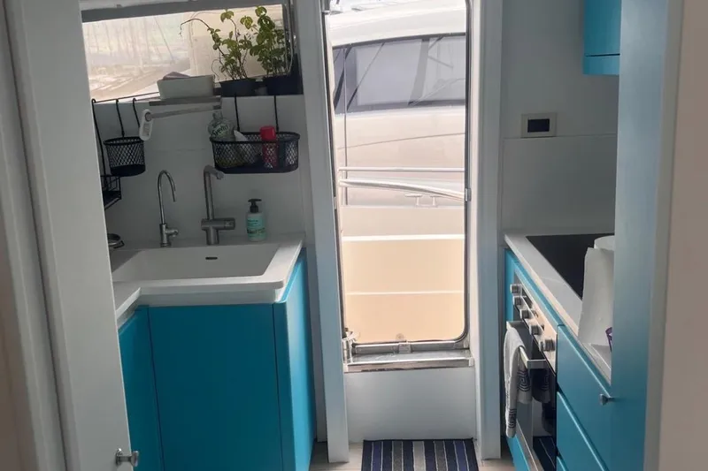  Yacht Photos Pics Compact kitchen on 2005 Posillipo Technema 80 yacht with blue cabinets and modern appliances.